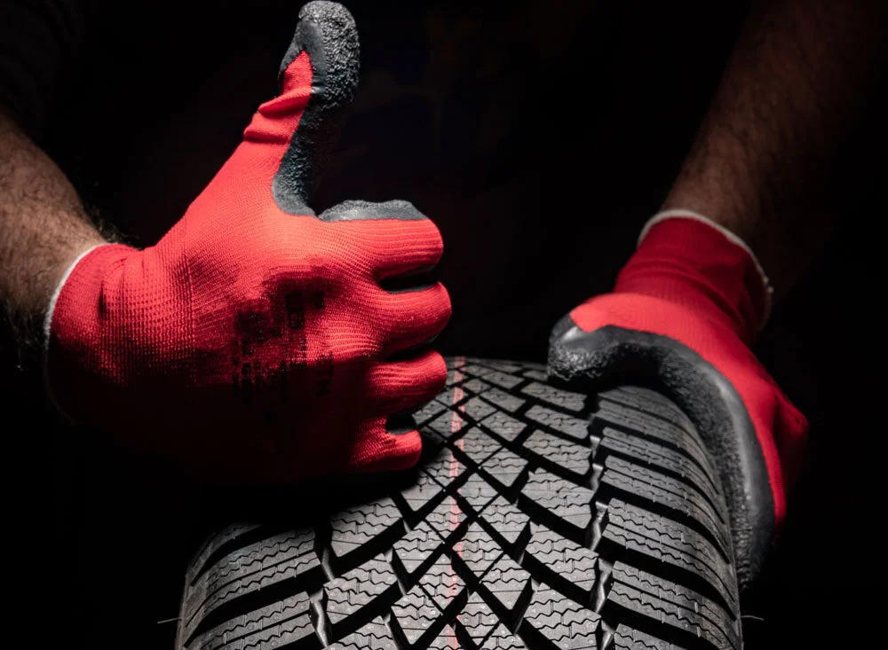Tire technician grabbing a tire.
