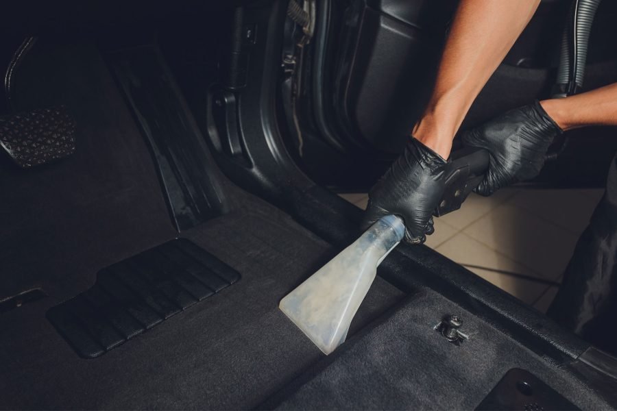 Detailer vacuuming the car's interior